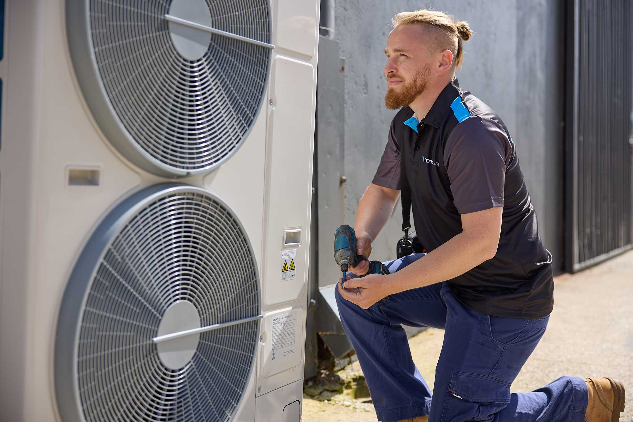 Total Air technician installing a split system outdoor condenser